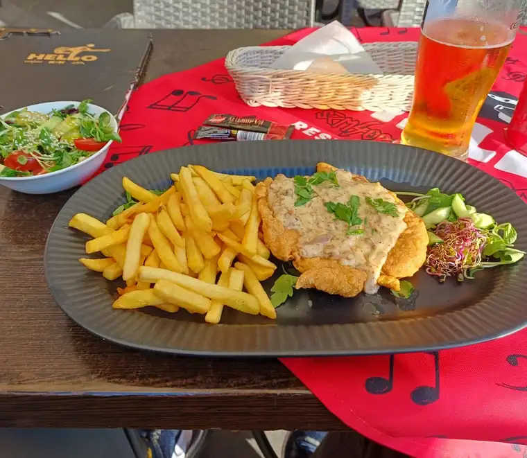 Kotlet z frytkami i surówką na talerzu